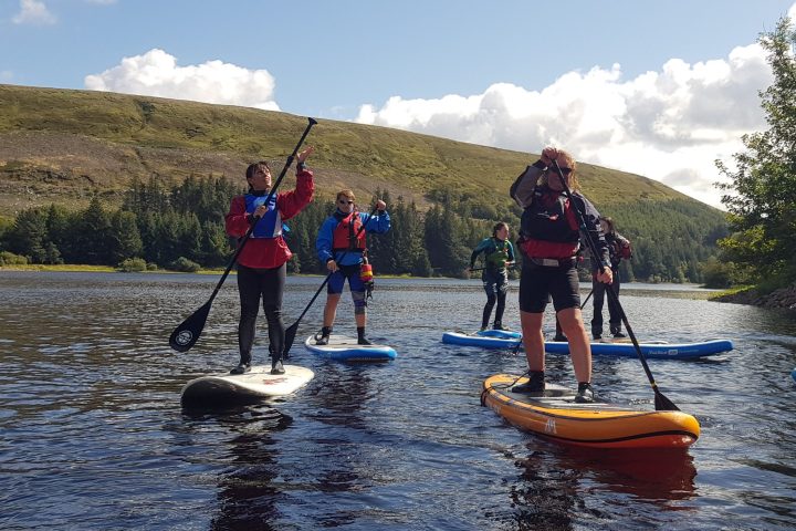 a group of people riding on the back of a boat in the water