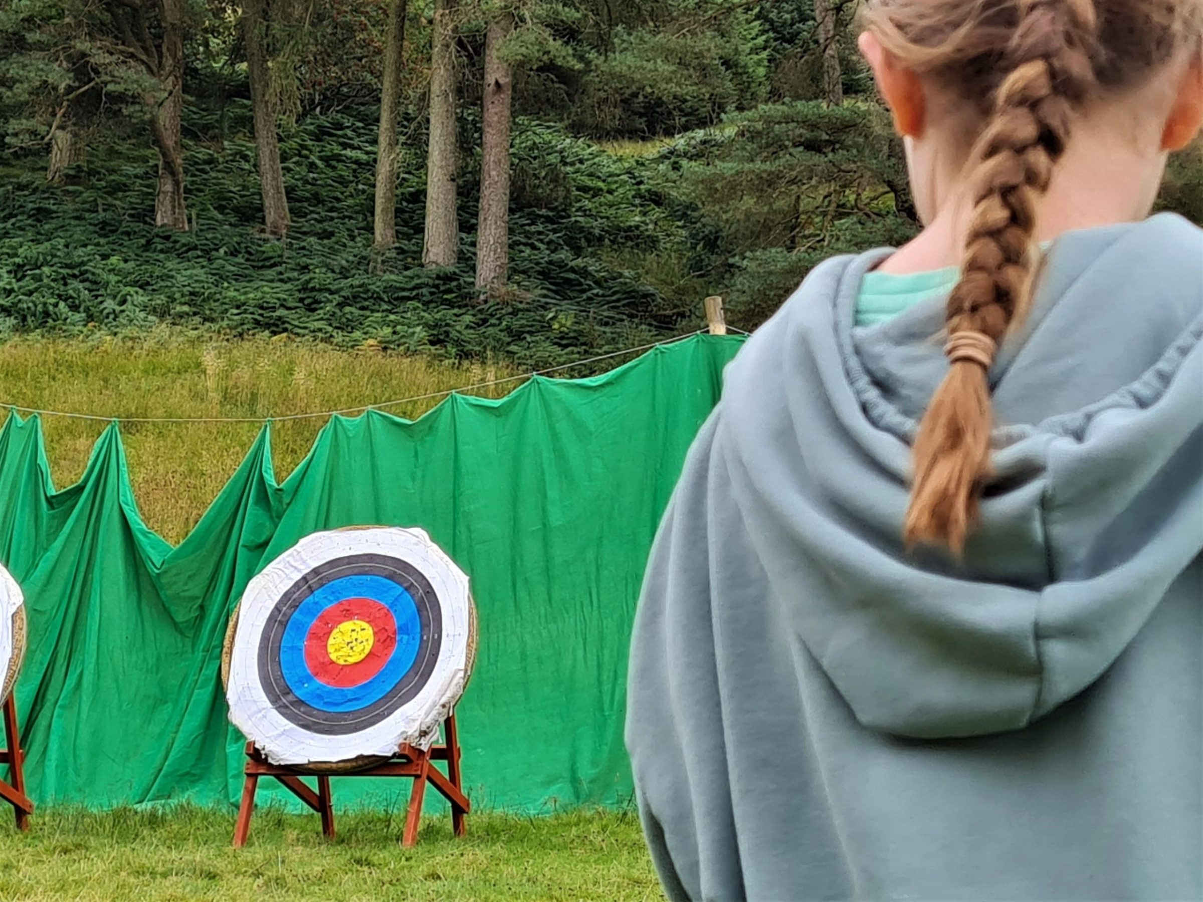 a person holding a kite while standing in the grass