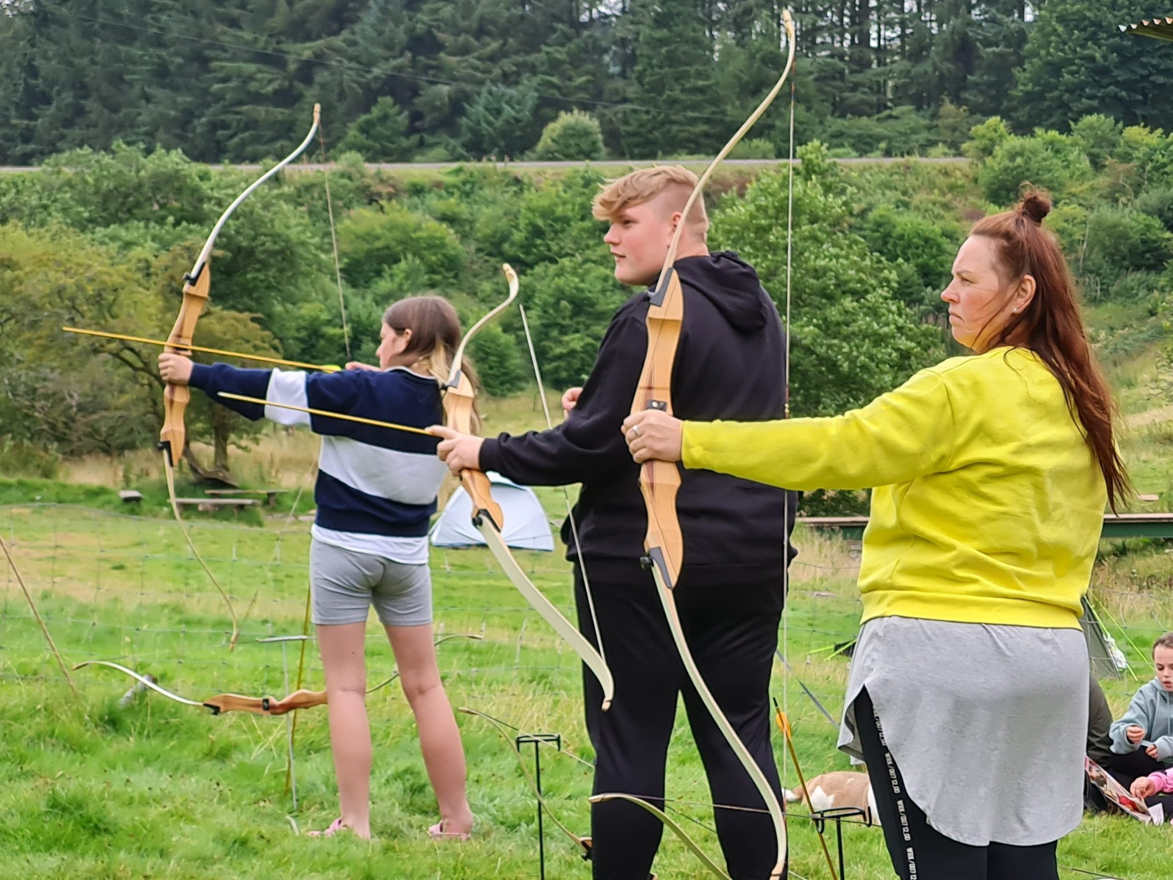 a group of people in a field flying a kite