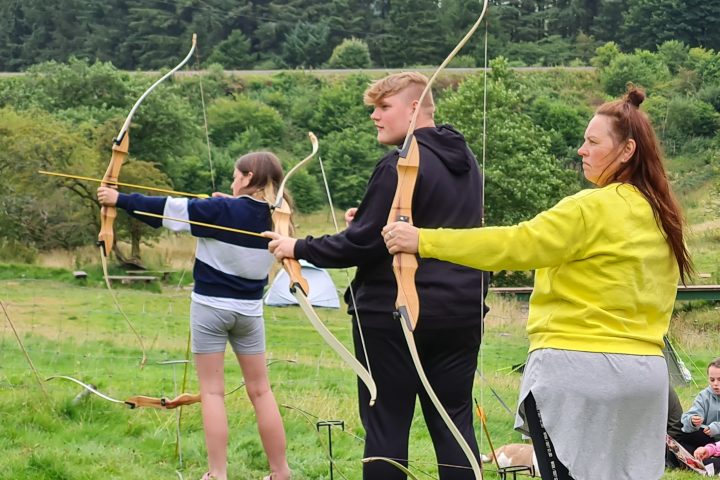 a group of people in a field flying a kite