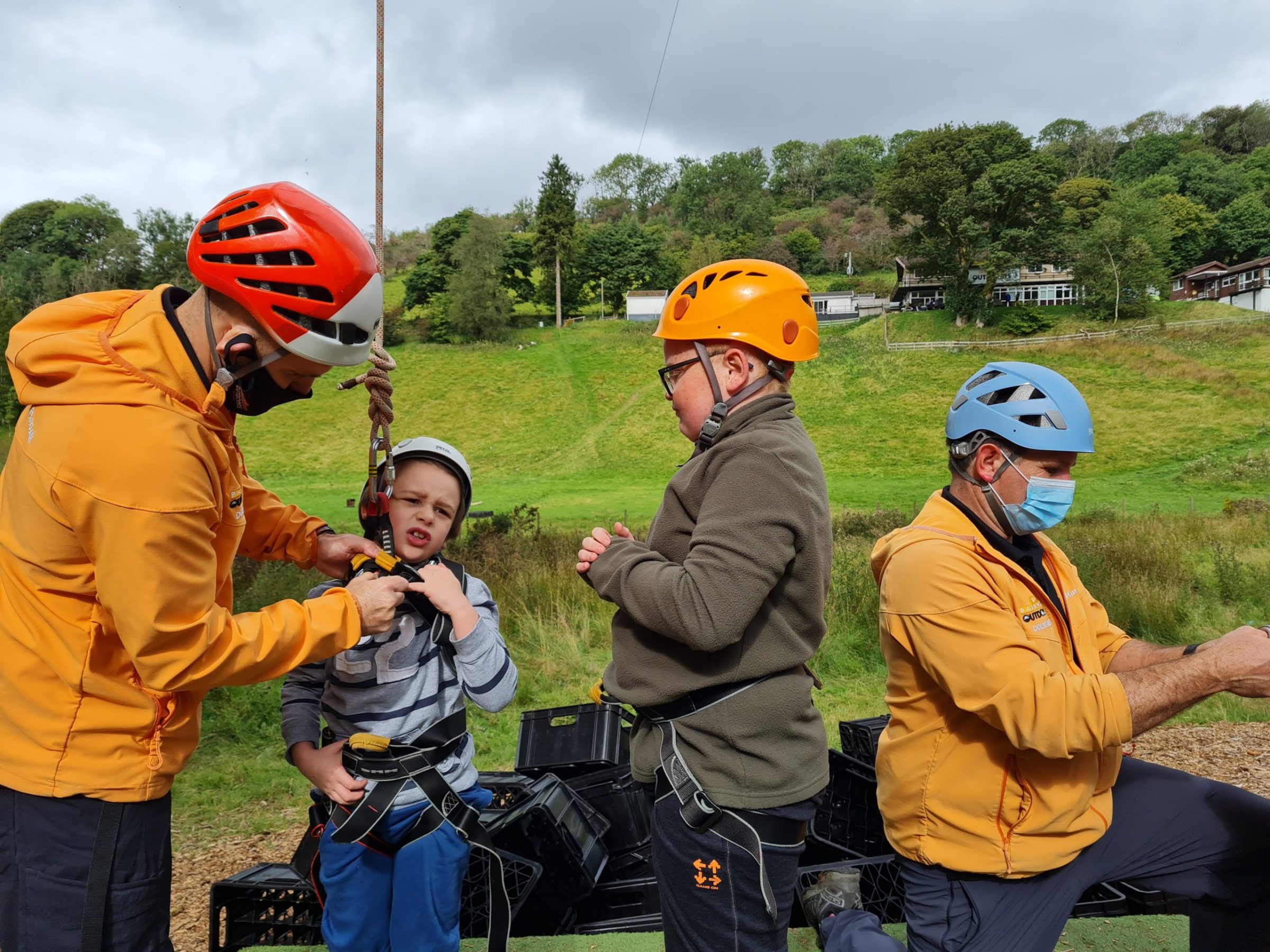 a group of people that are standing in the grass holding a baseball bat