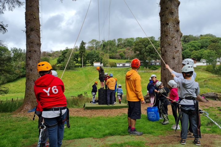 a group of people standing on top of a grass covered field