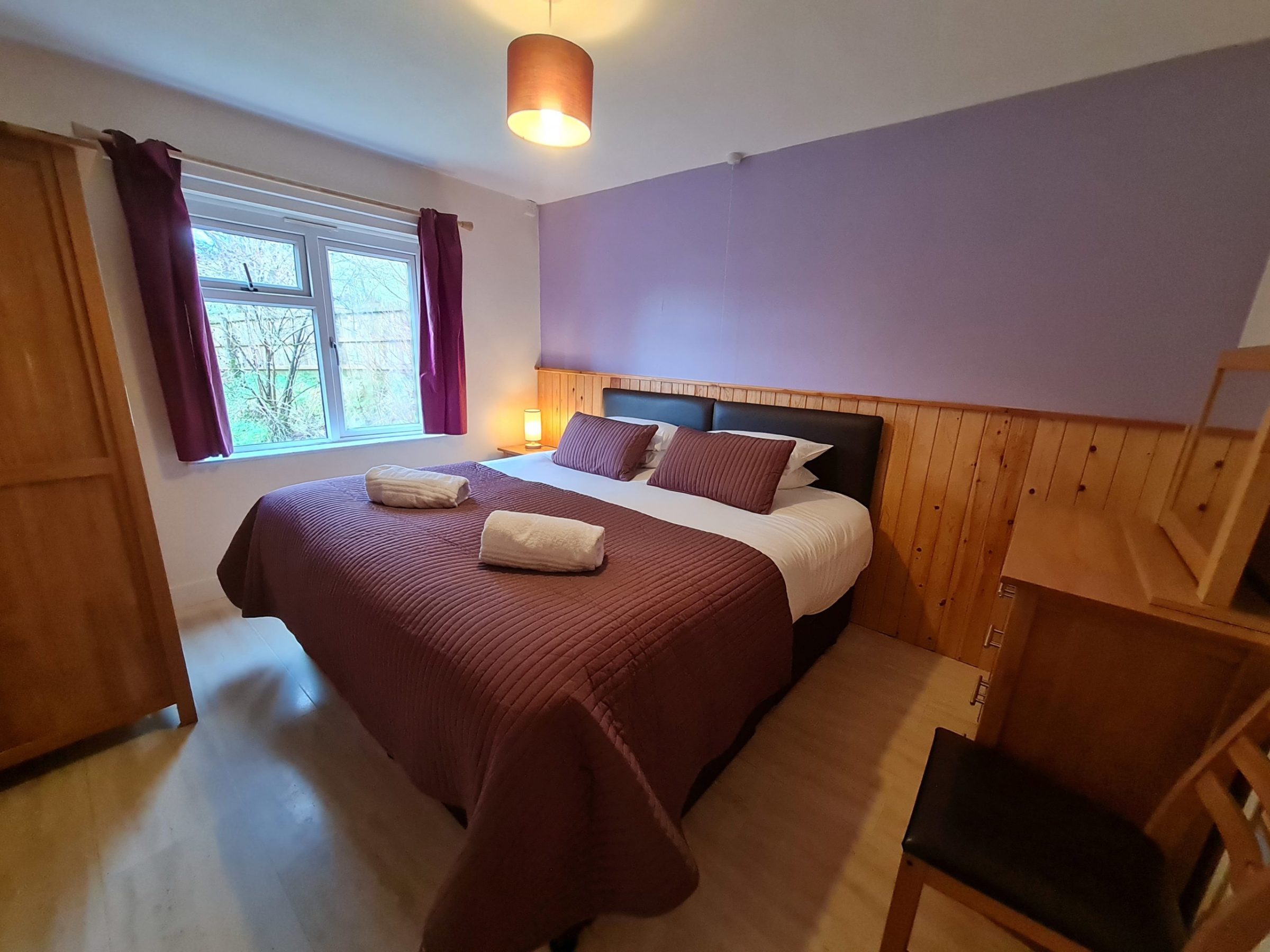 a bedroom with a bed and a chair in a room