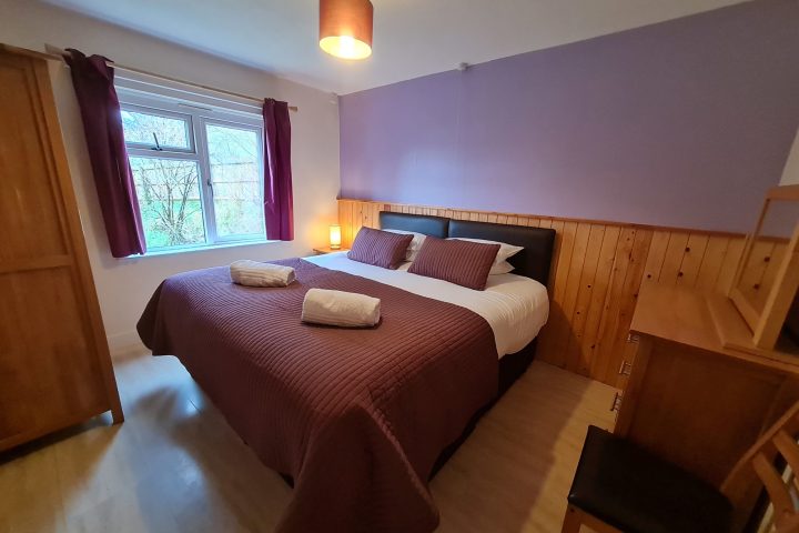 a bedroom with a bed and a chair in a room