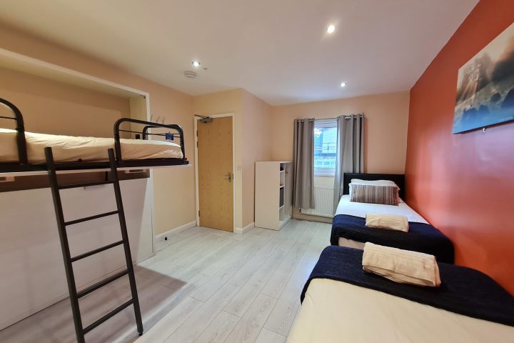 a bedroom with a bed and desk in a room