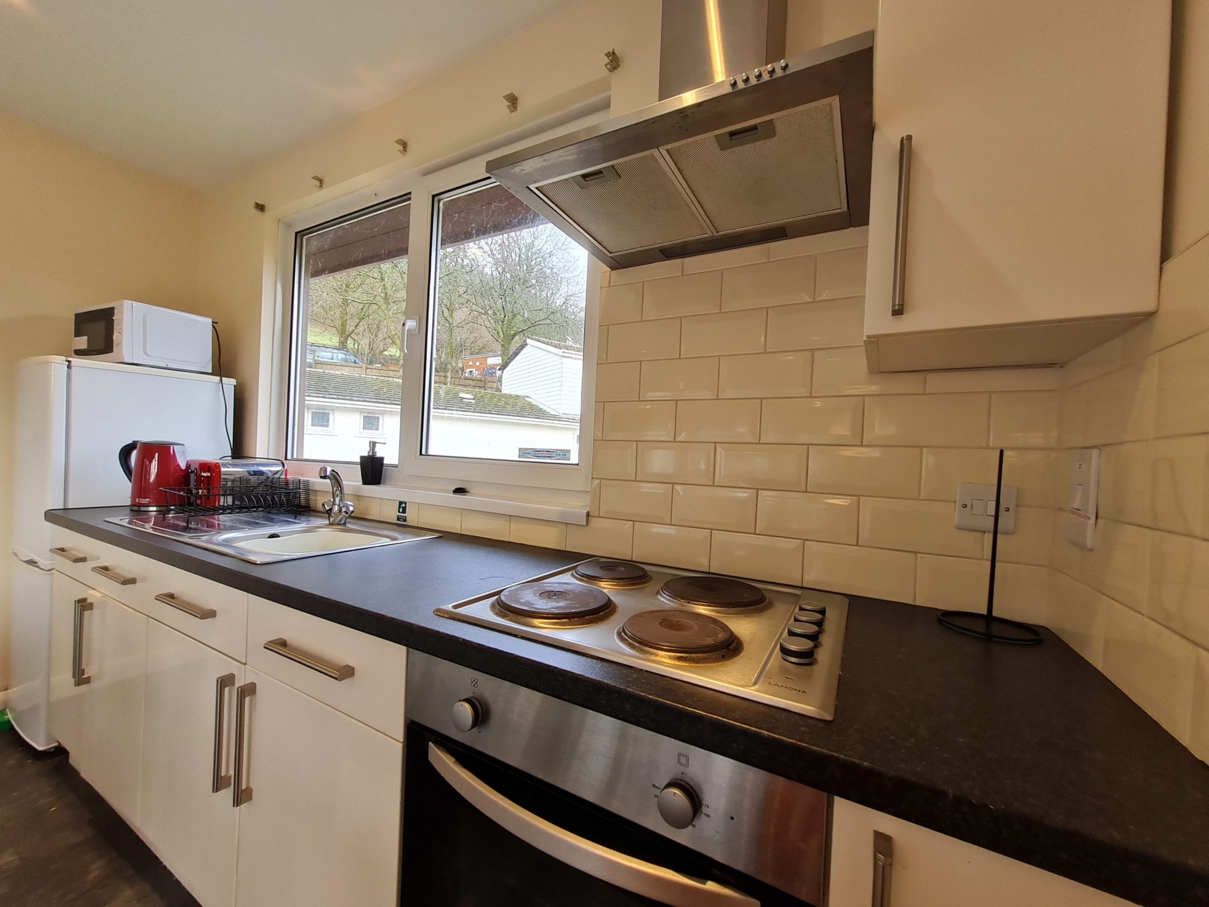 a kitchen with a stove a sink and a window