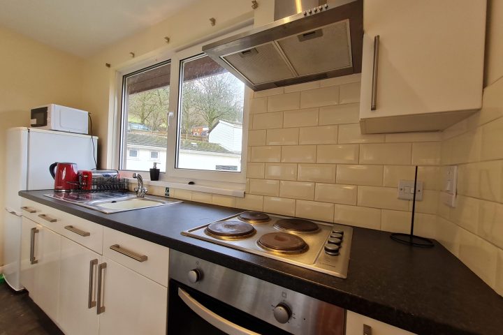 a kitchen with a stove a sink and a window