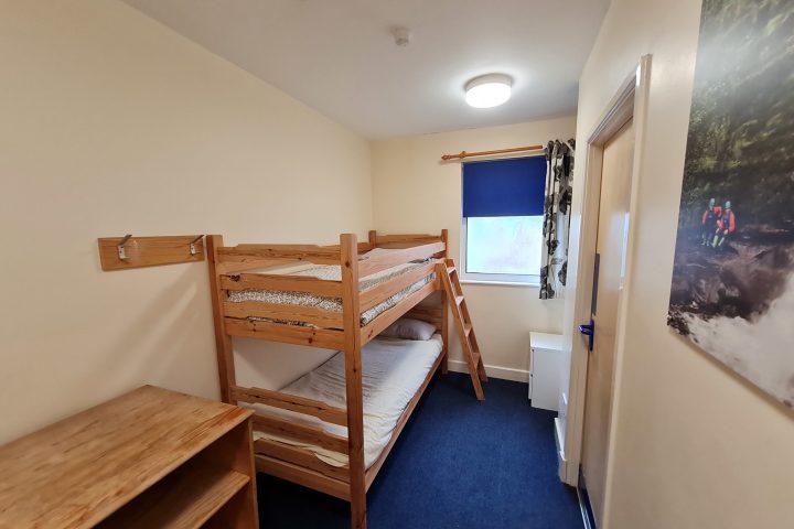 a bedroom with a bed and a chair in a room