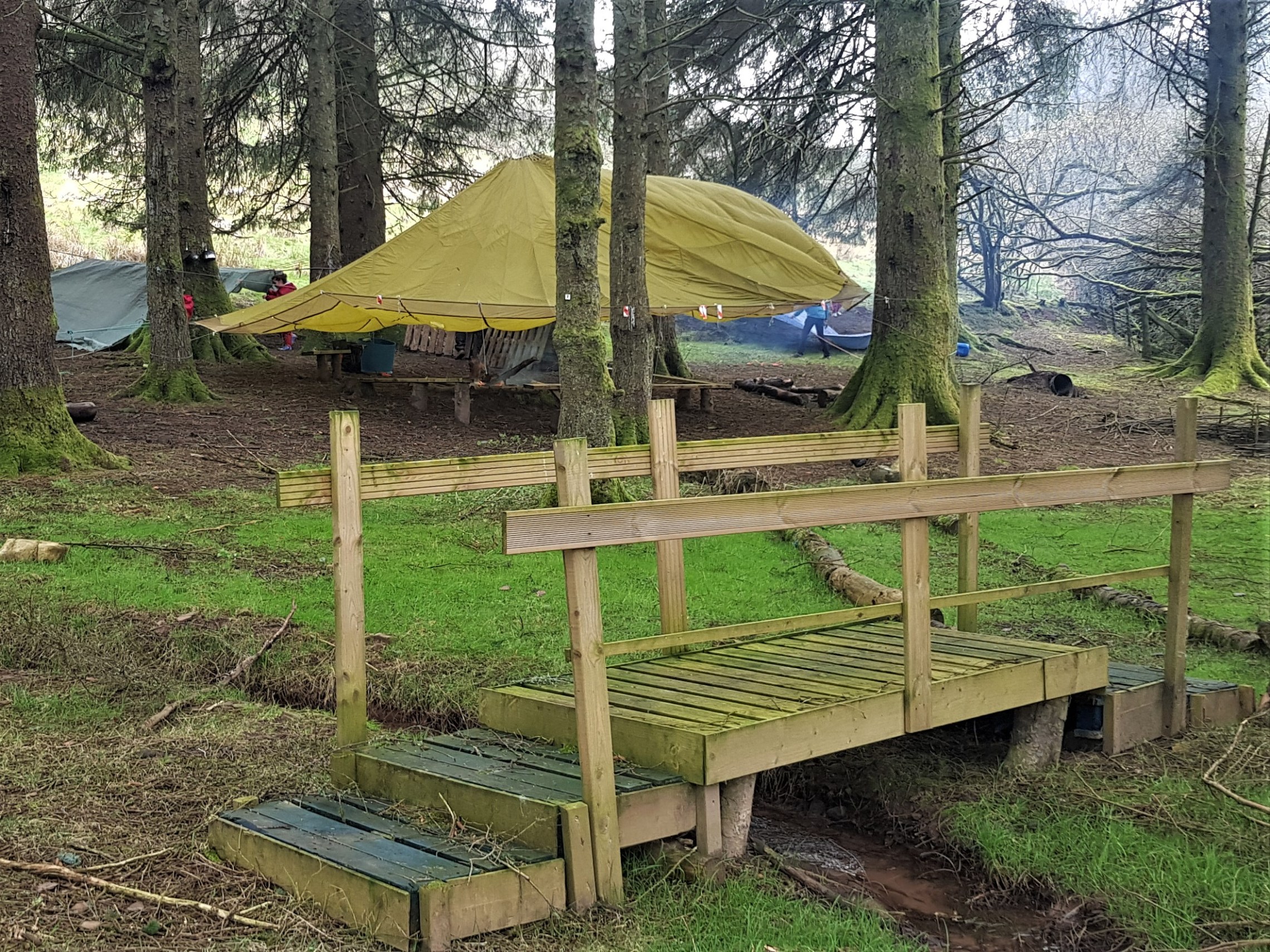 a couple of lawn chairs sitting on top of a grass covered field