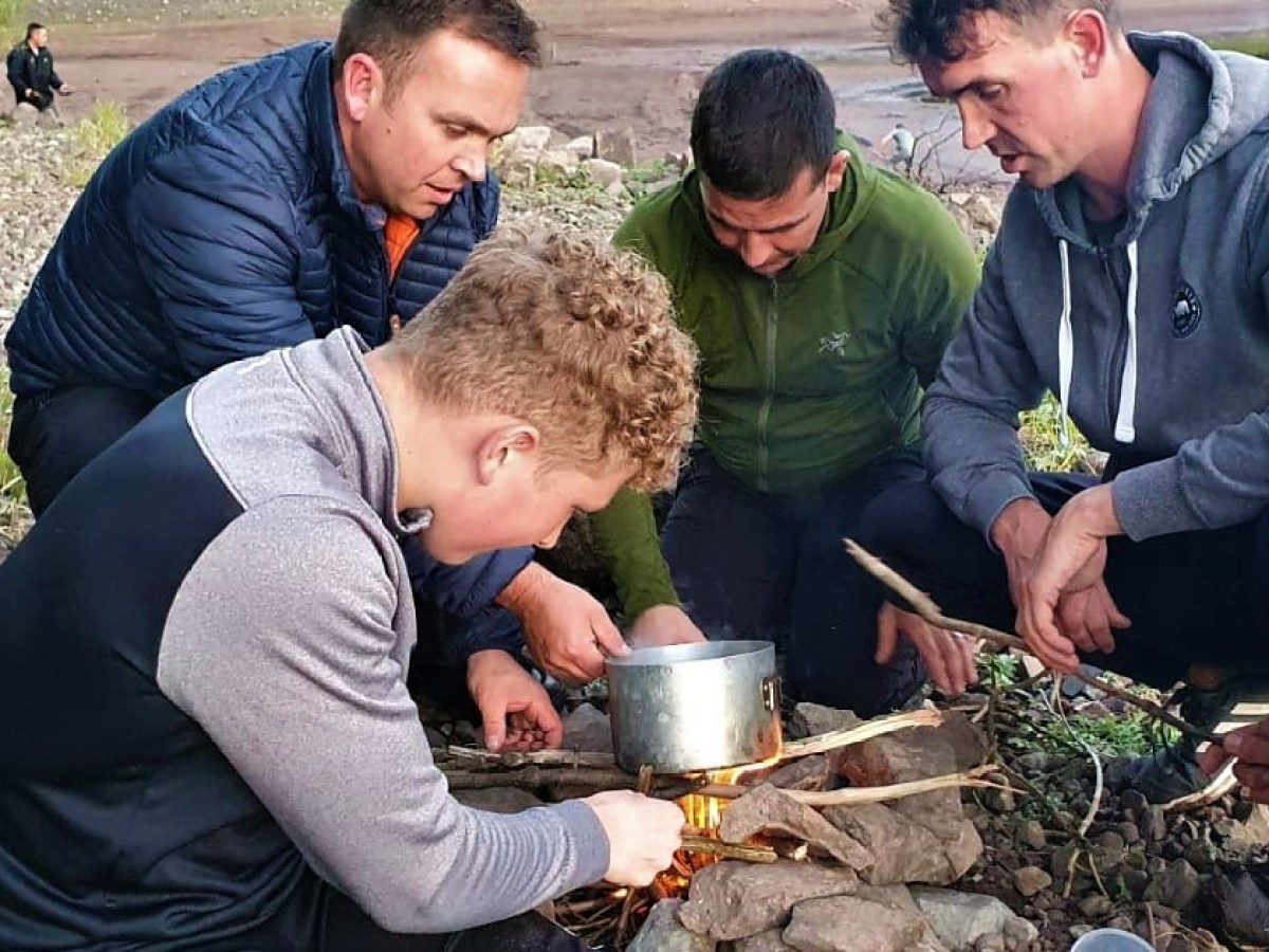 a group of people preparing food in a pan