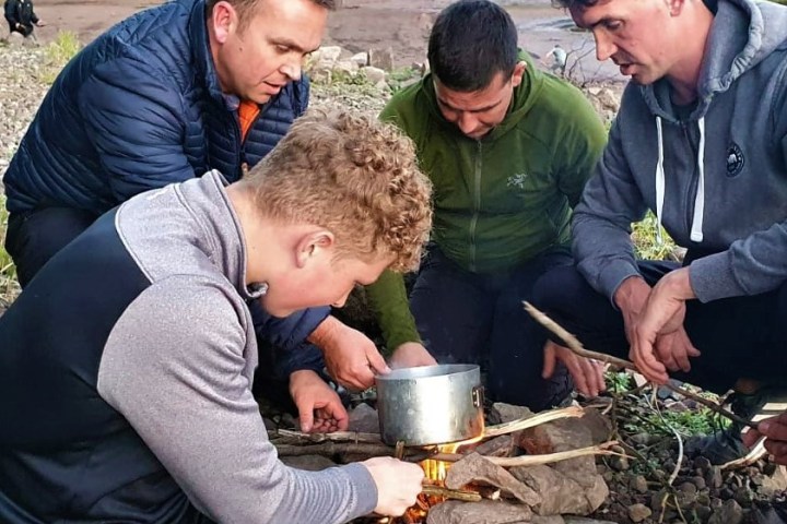 a group of people preparing food in a pan