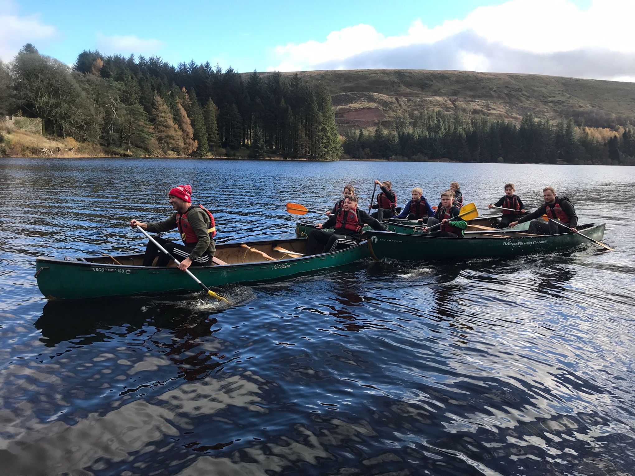 a group of people rowing a boat in the water