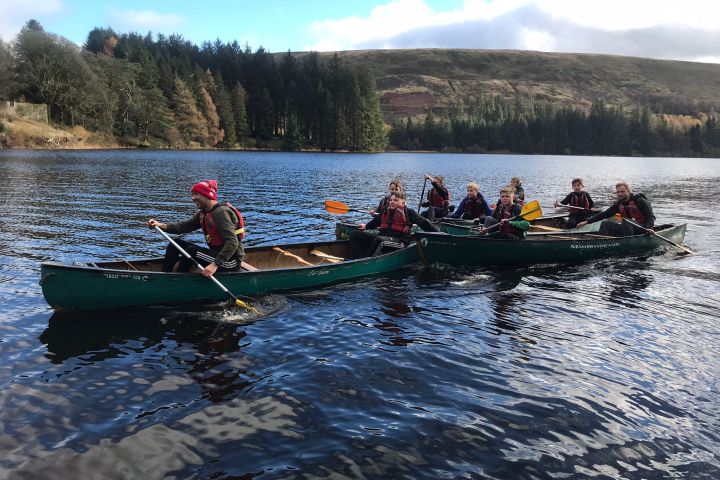 a group of people rowing a boat in the water