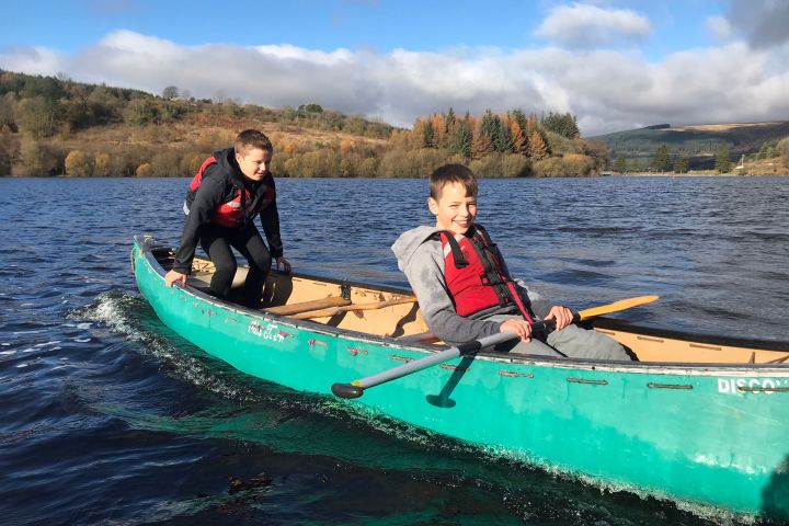 a group of people riding on the back of a boat in the water