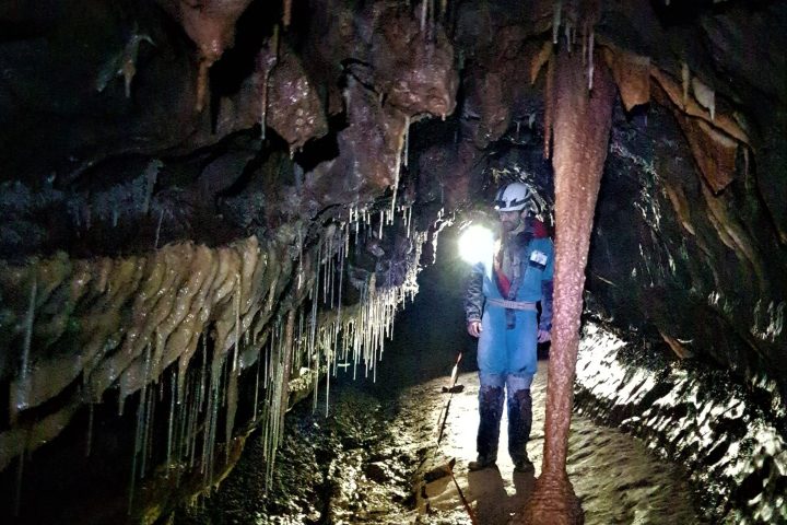 a man standing in front of a cave