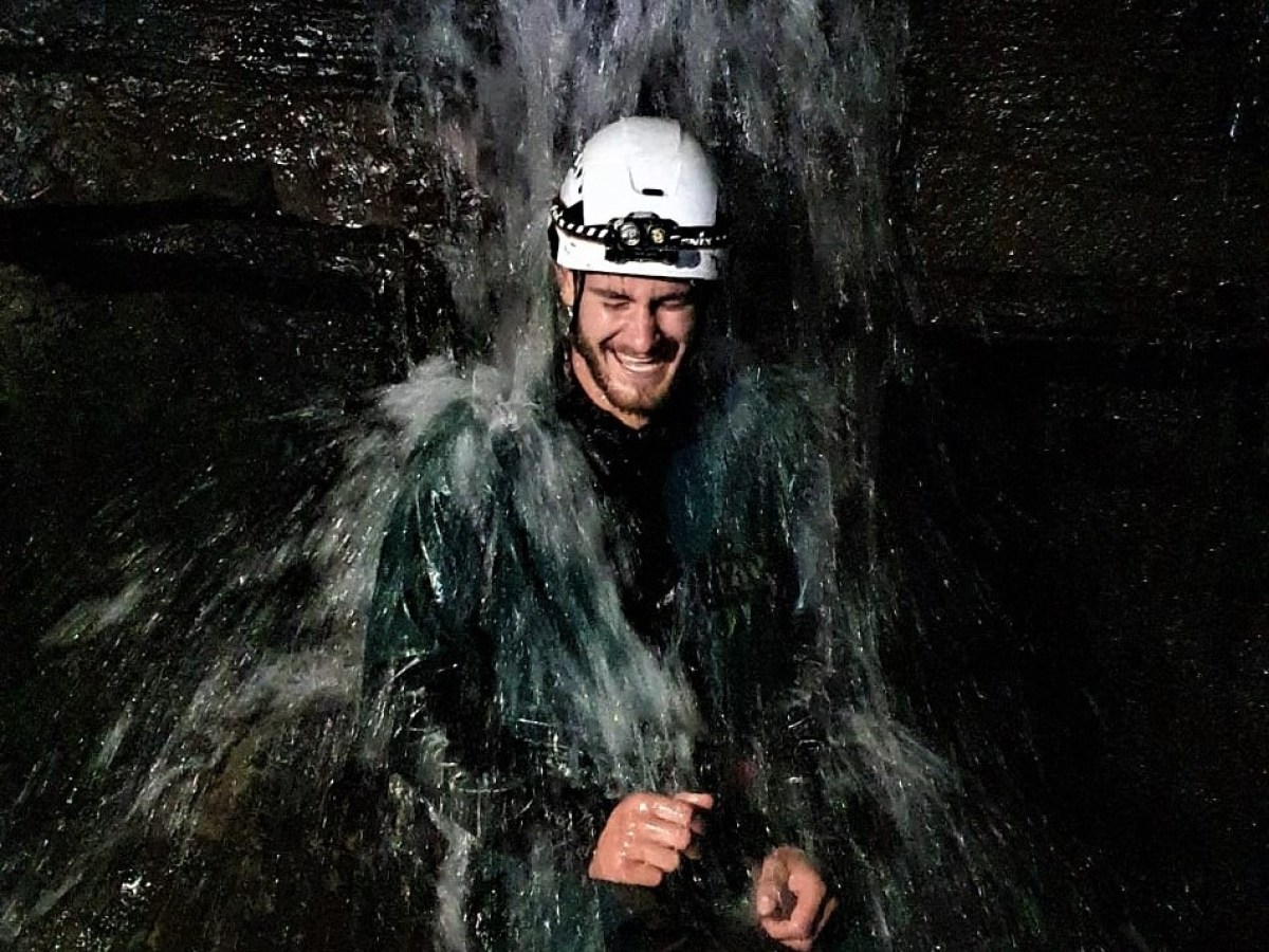 a person standing next to a waterfall