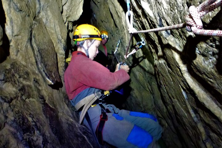 a person wearing a helmet and sitting on a rock