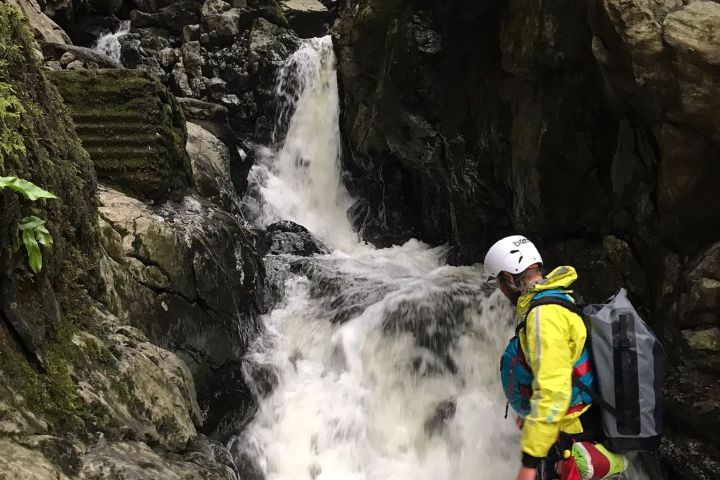 a man standing next to a waterfall