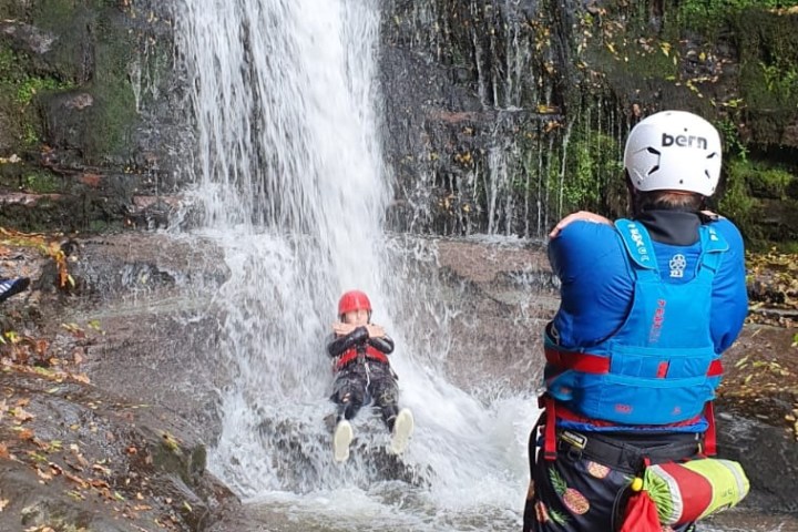 a group of people riding on the back of a waterfall