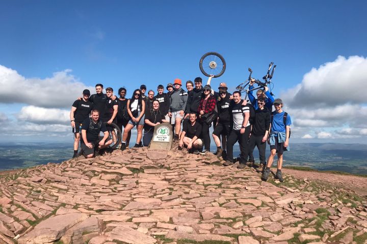 a group of people standing on top of a sandy beach