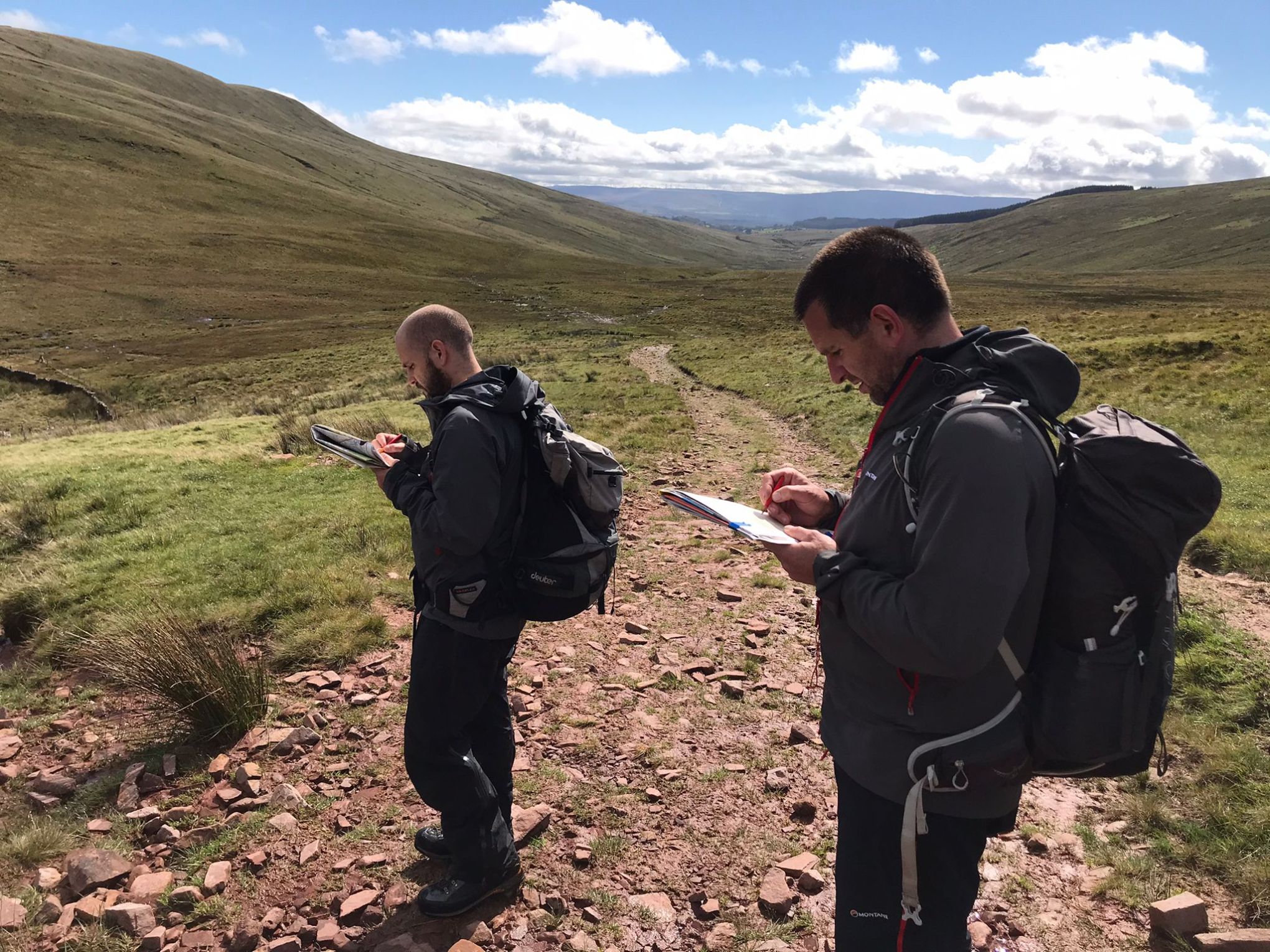 a man and a woman standing in front of a mountain