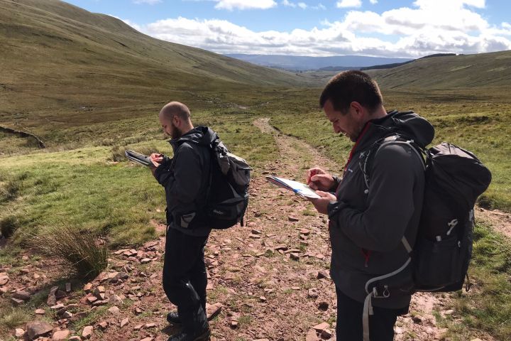 a man and a woman standing in front of a mountain