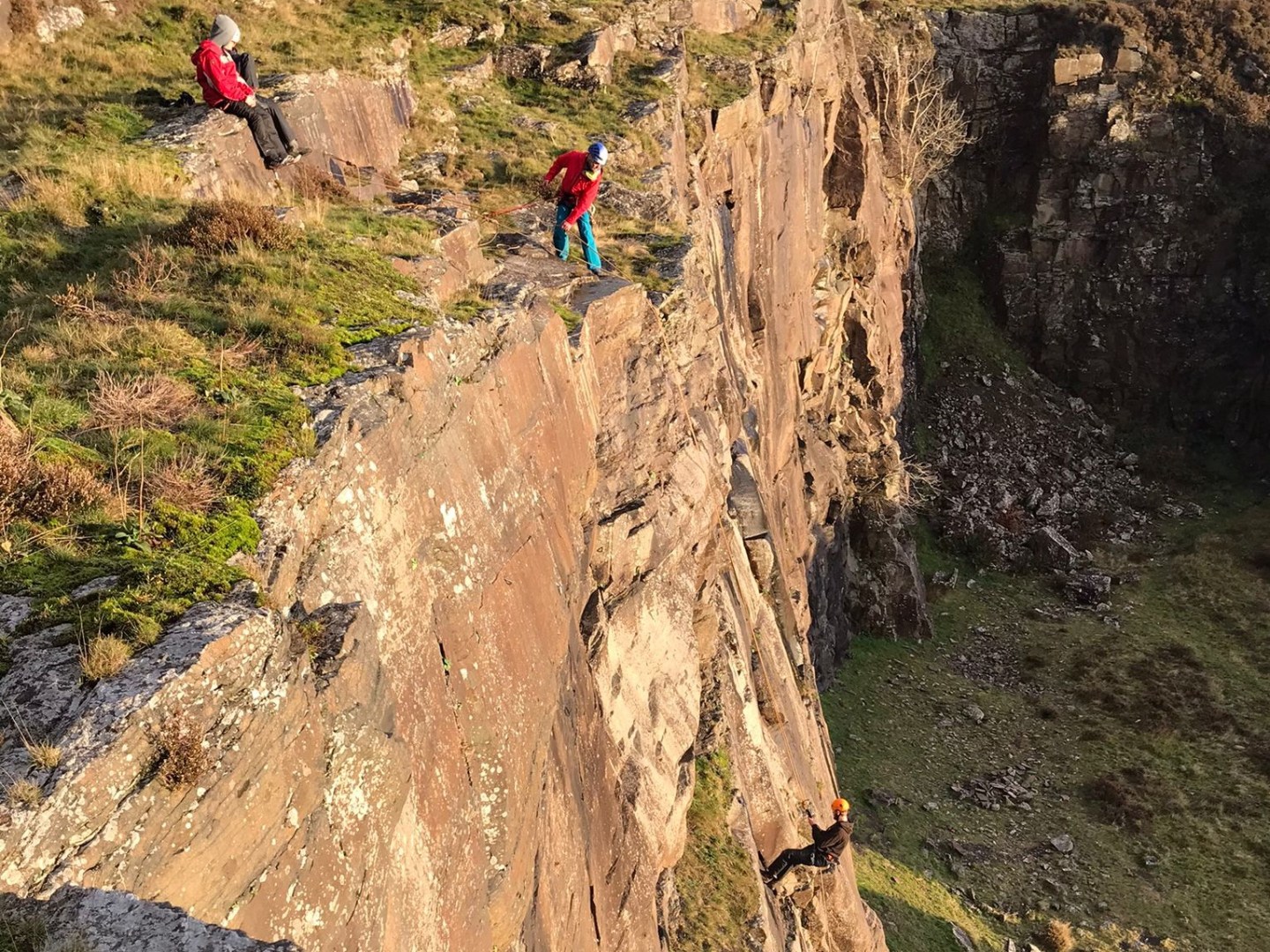 a person flying a kite on the side of a mountain