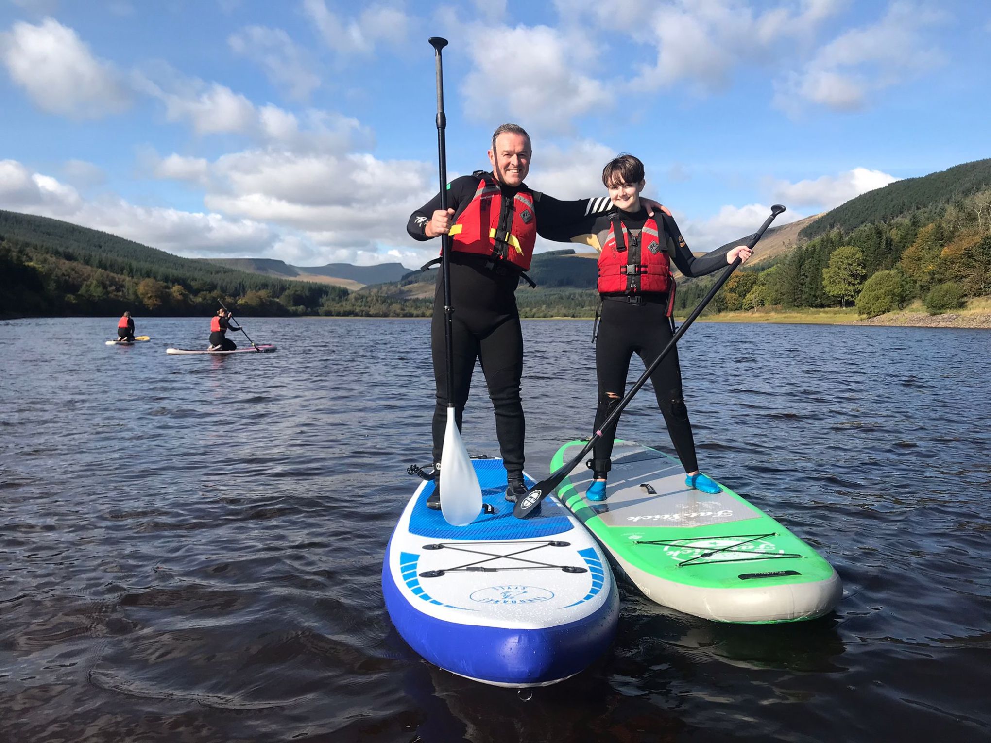 a group of people standing next to a body of water