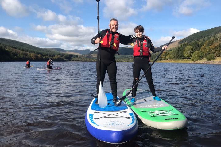 a group of people standing next to a body of water