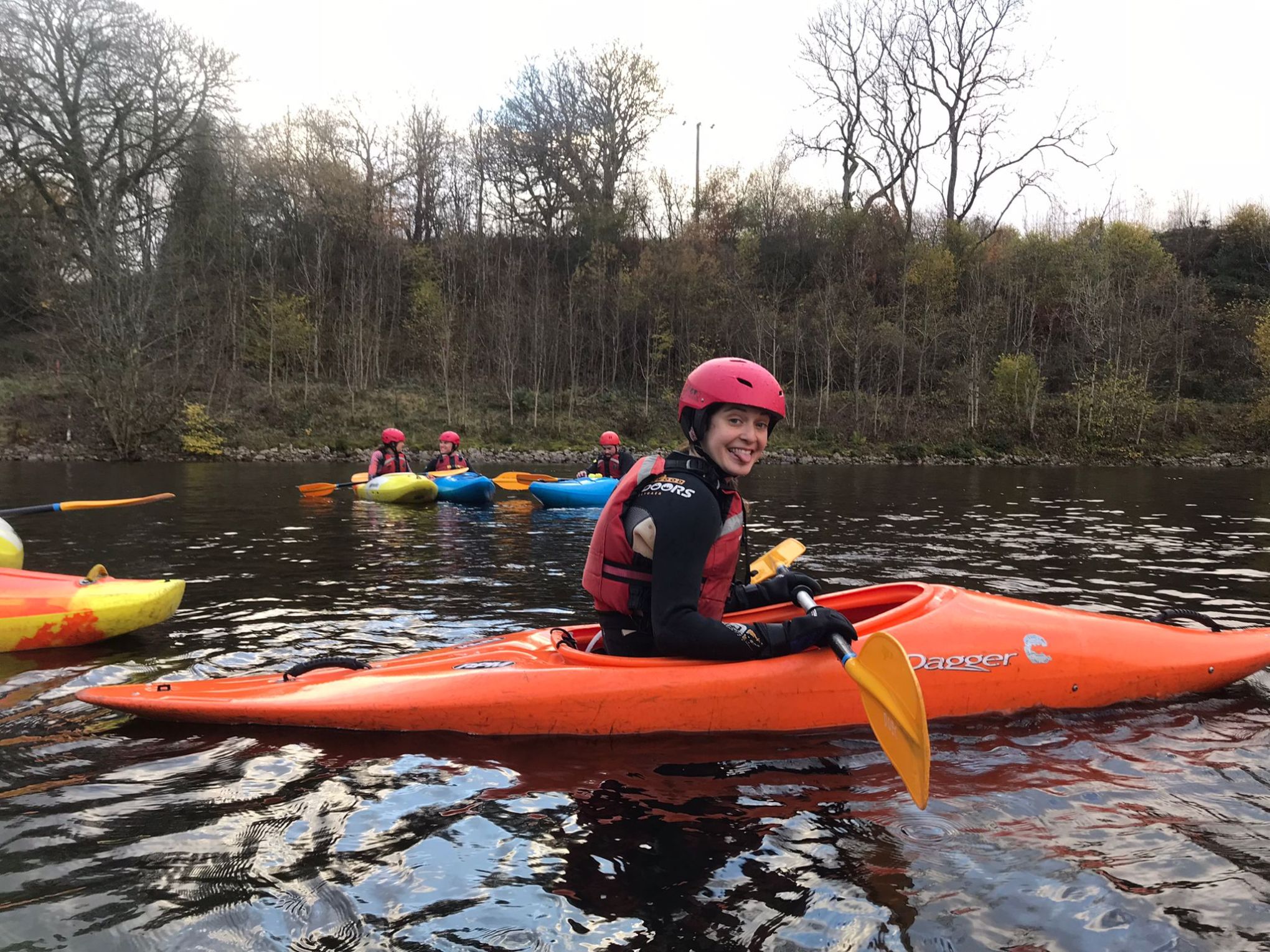 a little girl riding on the back of a boat in the water