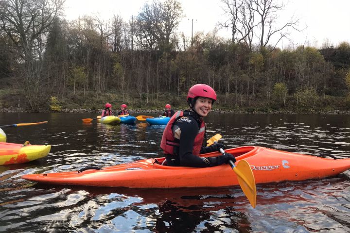 a little girl riding on the back of a boat in the water