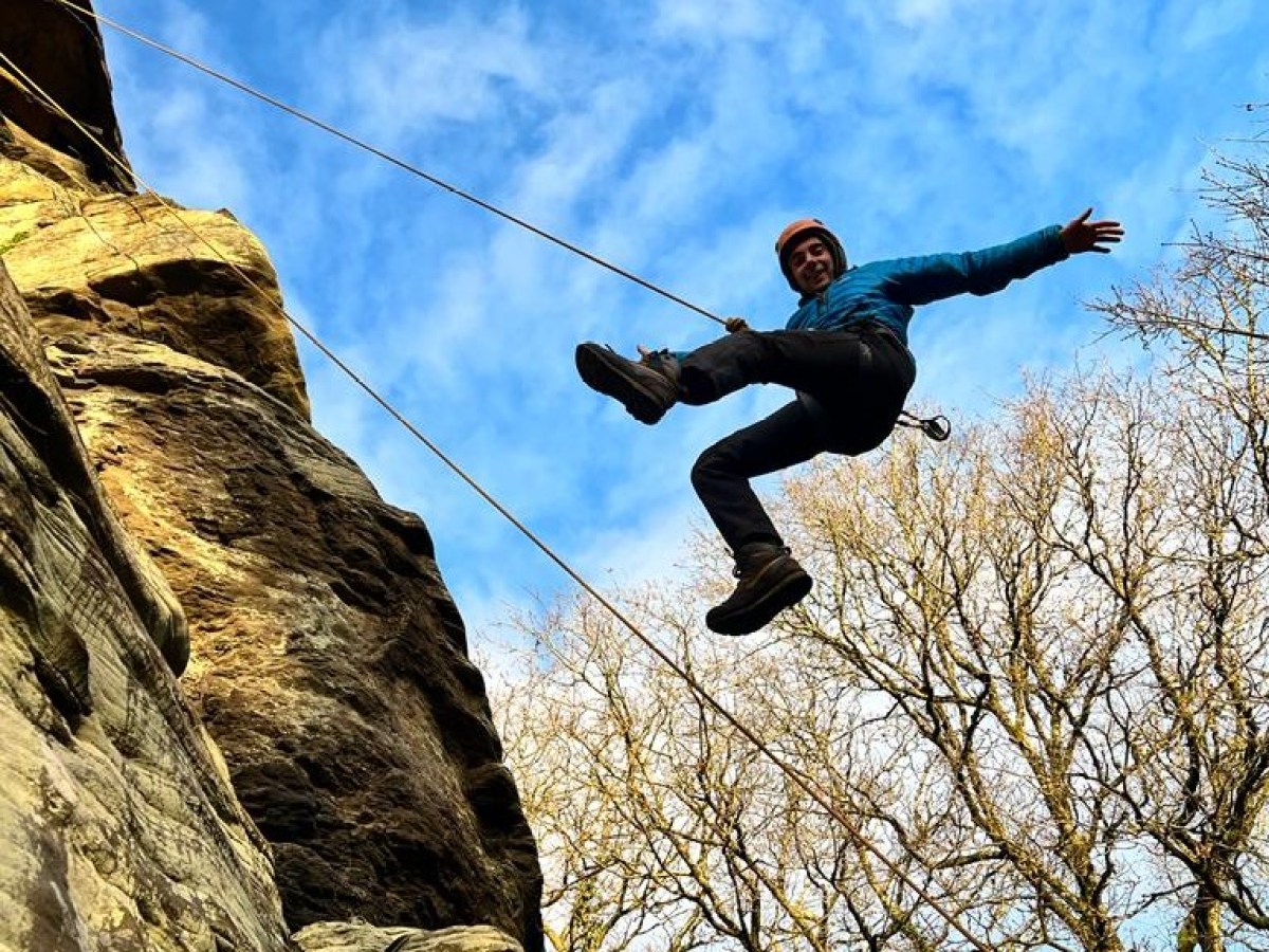 a man flying through the air on a rock