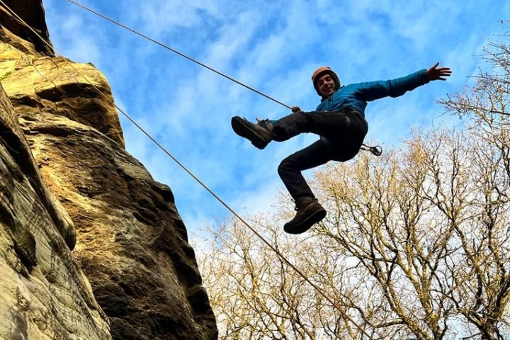a man flying through the air on a rock