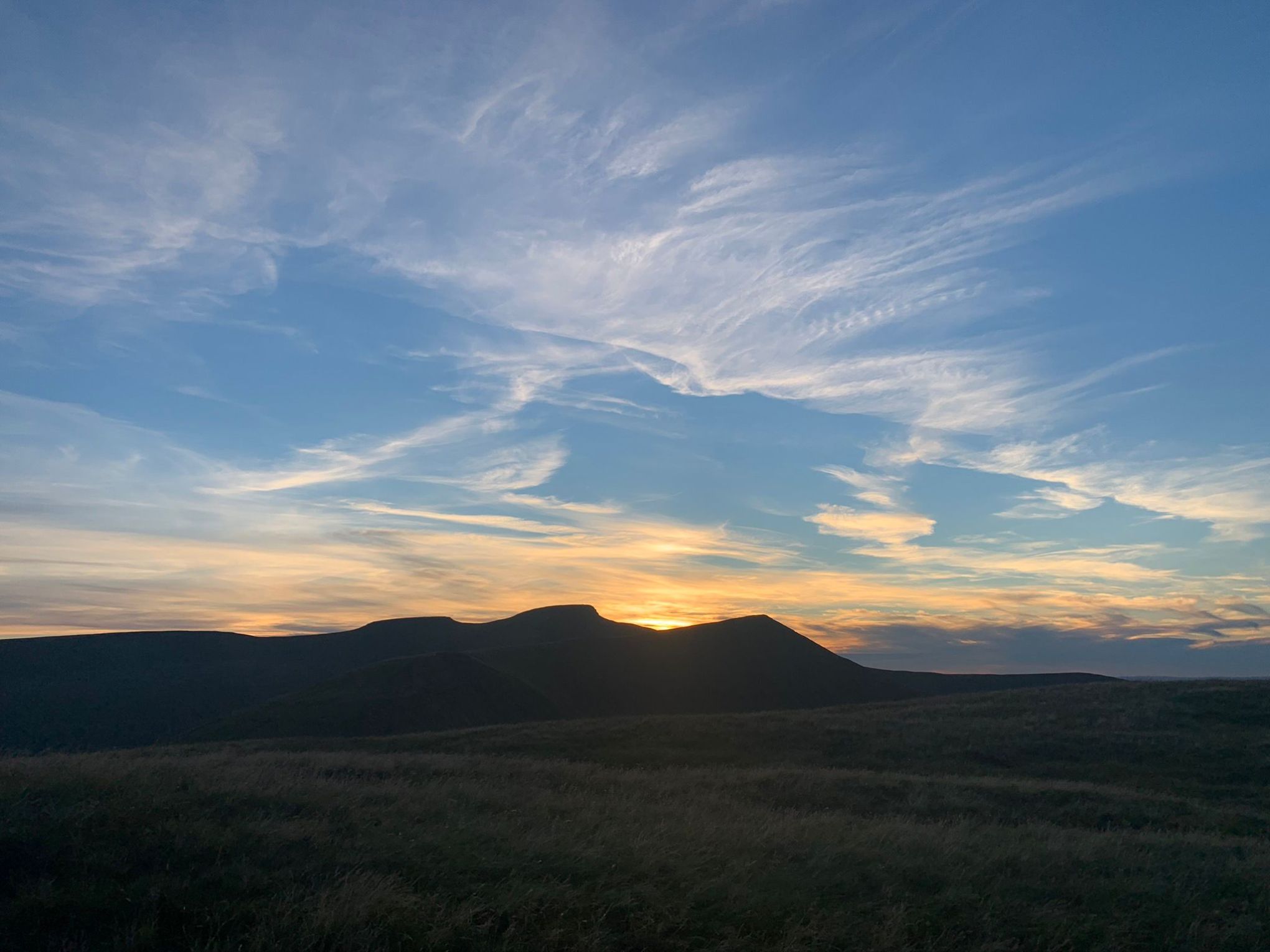 a sunset over a grass field