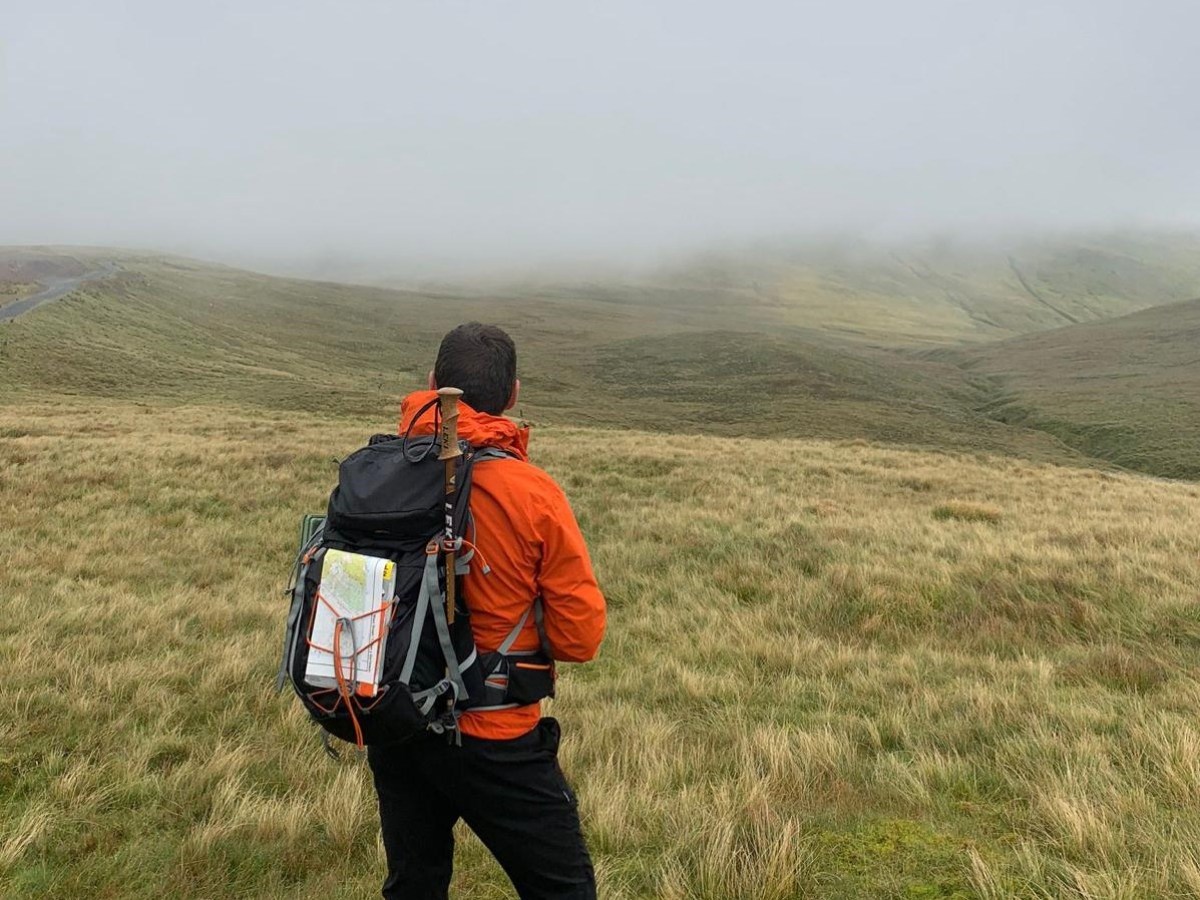 a man standing on top of a grass covered field