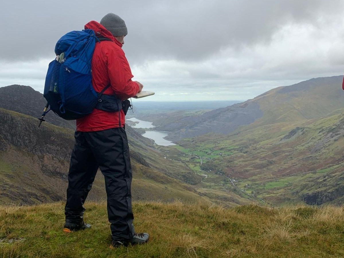 a man standing on a grassy hill
