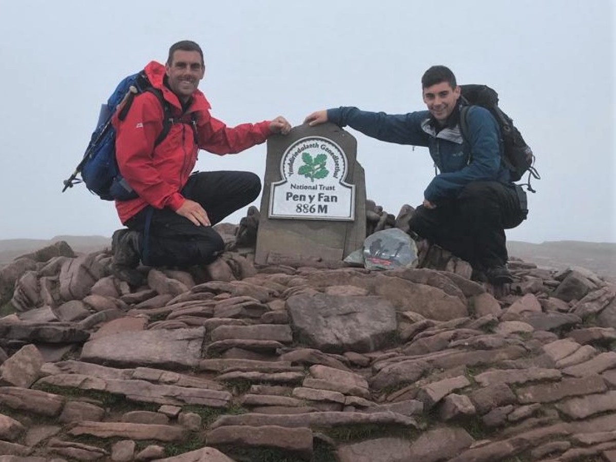a man and a woman sitting on a rock