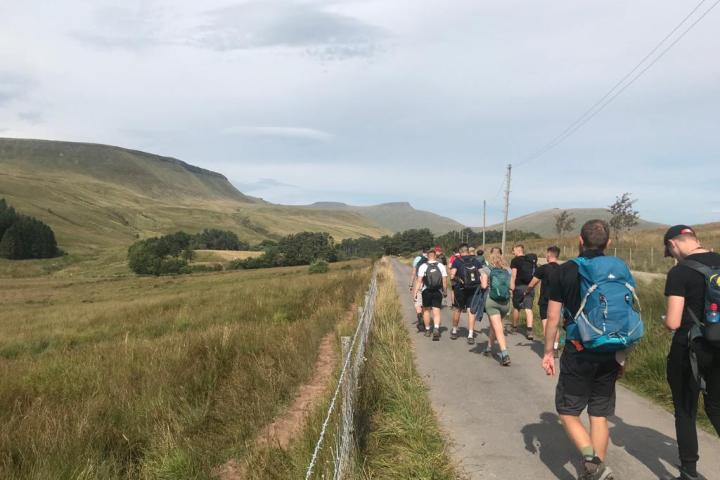 a group of people walking down a dirt road