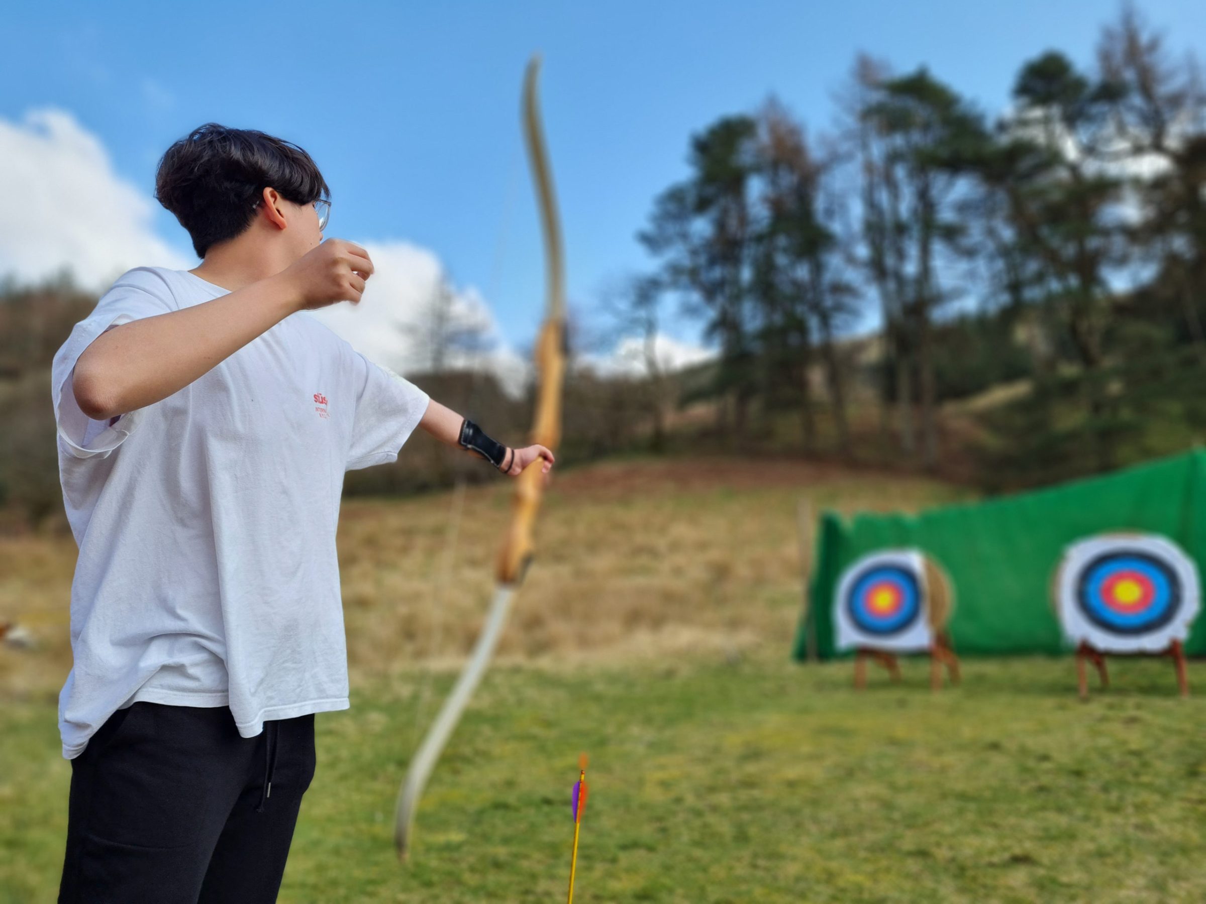 a young boy flying a kite in a field