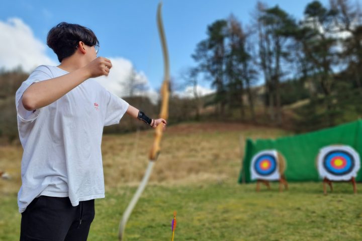 a young boy flying a kite in a field