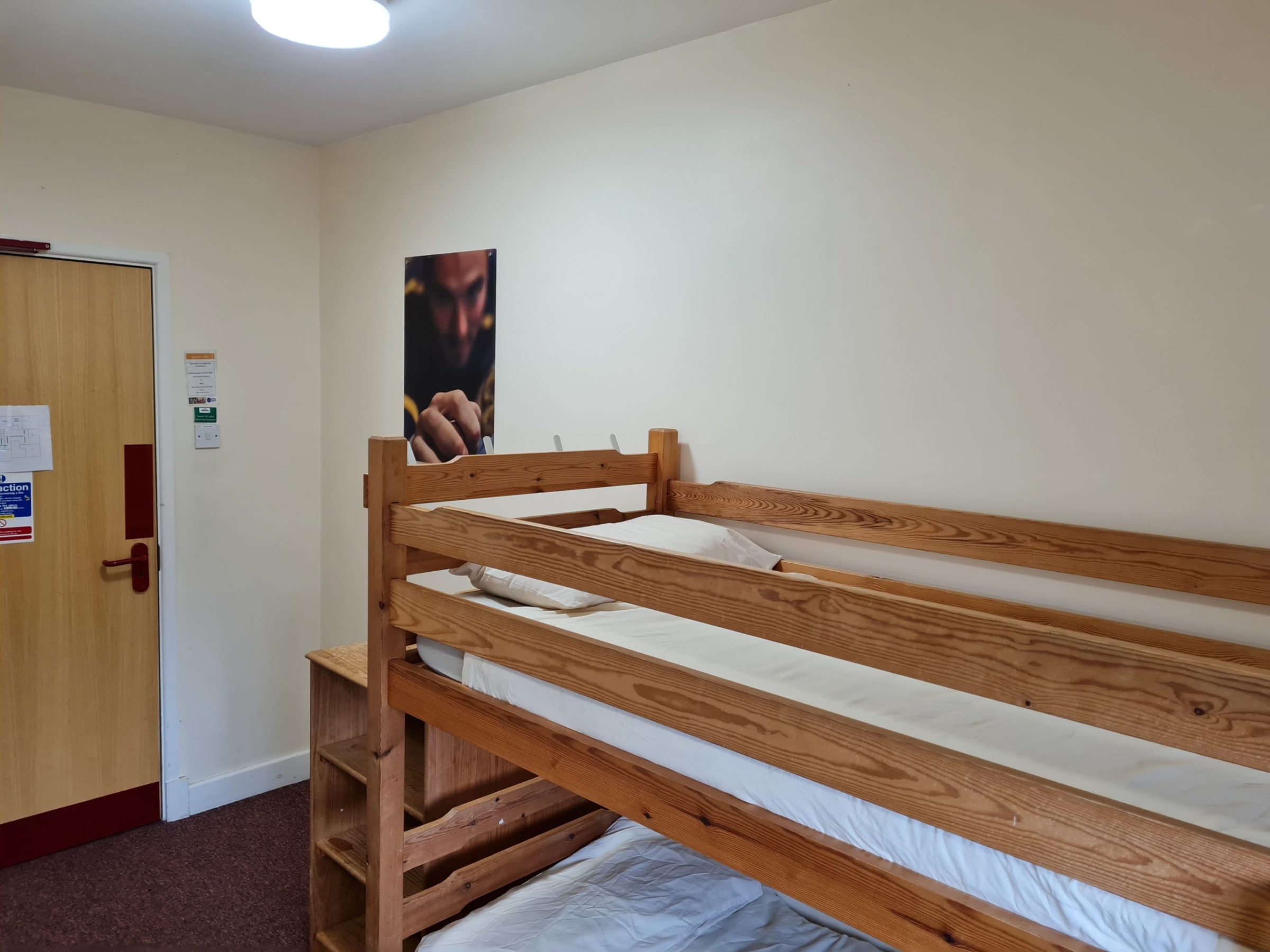 a bedroom with a bed and a chair in a room
