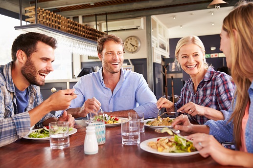 a group of people sitting at a table with a plate of food