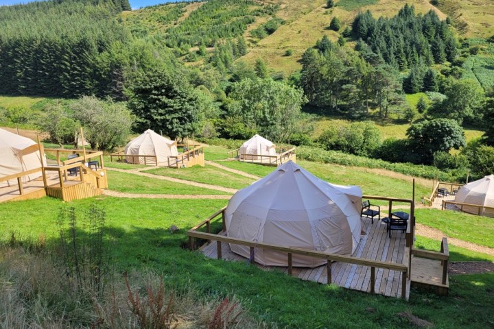 a group of lawn chairs sitting on top of a lush green field