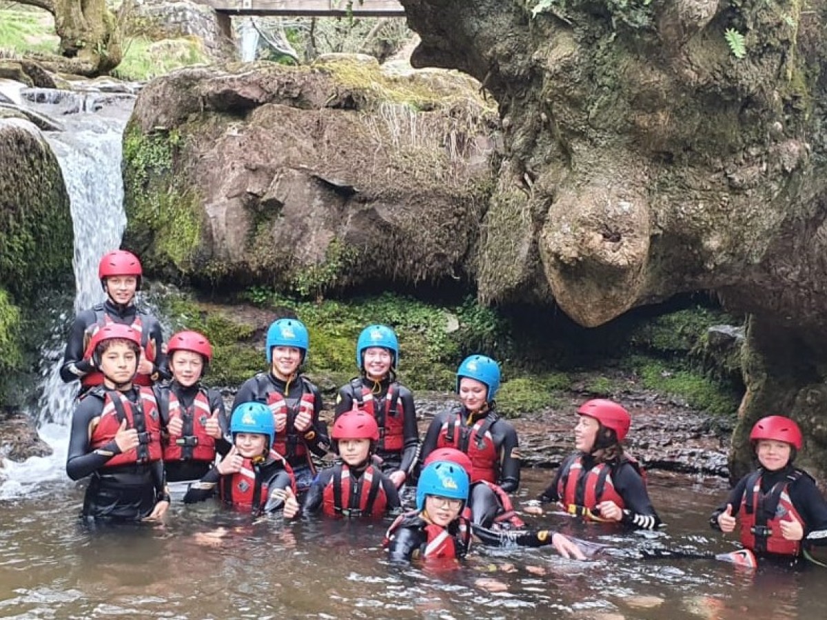 a group of people on a rock next to water