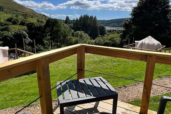 an empty park bench next to a fence
