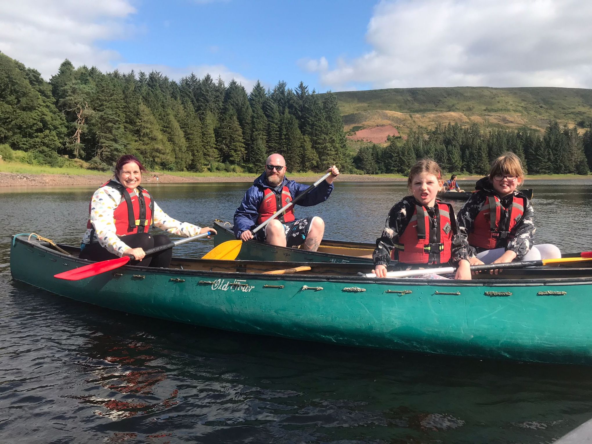 a group of people riding on the back of a boat in the water