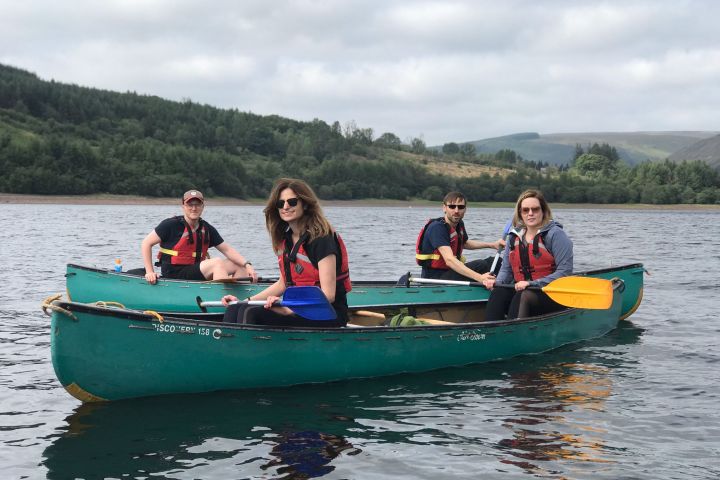 a group of people riding on the back of a boat in the water