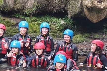 a group of people on a rock next to water