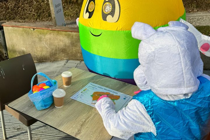 a person sitting at a table with a blue umbrella